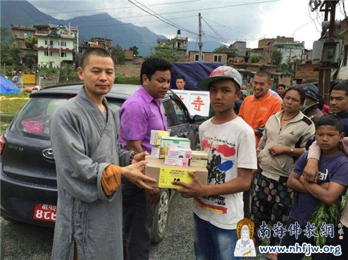 当地灾民双手接过中勇法师救援物品
