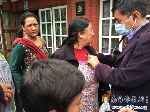 救援队中的医护人员正在为灾民做医护检查