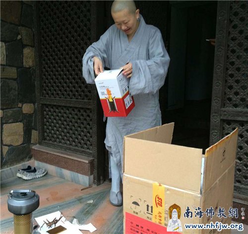 顿华法师从物资箱取出柴火炉,准备向救灾人员现场演示