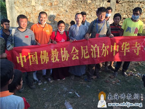 当地村民高举横幅,欢迎救援队的到来