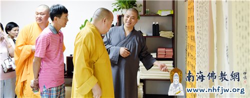 本焕寺监院常志法师向参观组一行介绍学员作品