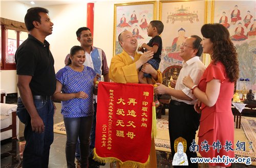 Dulen一家赠送印顺大和尚“大爱无疆 再造父母”锦旗 ,大和尚慈爱地抱起Dulen,现场欢喜温暖 摄影:林恩
