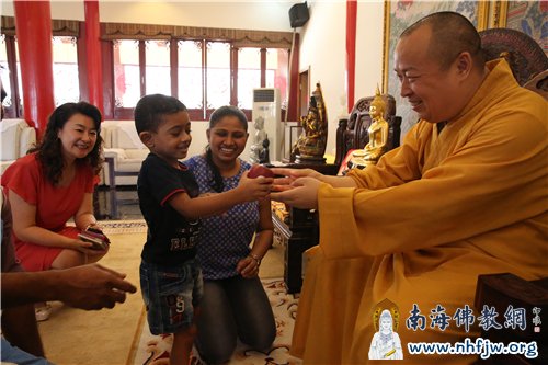 Dulen开心地接过大和尚送的苹果 摄影:林恩